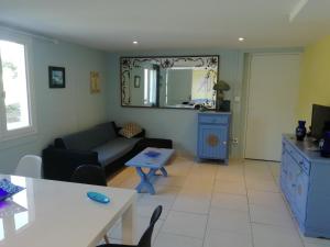 ein Wohnzimmer mit einem Sofa und einem Tisch in der Unterkunft Gîte le pastel in Puéchoursi