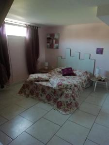 a bedroom with a bed with a bedspread on it at Gîte le pastel in Puéchoursi
