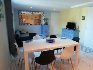 ein Esszimmer und ein Wohnzimmer mit einem Tisch und Stühlen in der Unterkunft Gîte le pastel in Puéchoursi