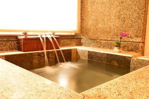 a sink with a stream of water in a bathroom at YingChia SPA Homestay in Luye