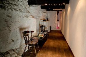 蒙布蘭萊班的住宿－Gîte Chambres d'hôtes Le Bellevue，石墙内的房间,配有椅子和桌子
