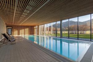 a large swimming pool in a building with windows at Green apartmány in Čeladná