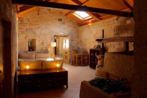 a living room with a couch and a stone wall at Casa Rural A Bouciña in Hio
