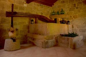 a living room with a stone wall and a fireplace at Casa Rural A Bouciña in Hio