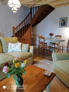 ein Wohnzimmer mit einem Sofa und einem Tisch in der Unterkunft Le Cerisier et Le Petit Cerisier in L'Etang des Faures 