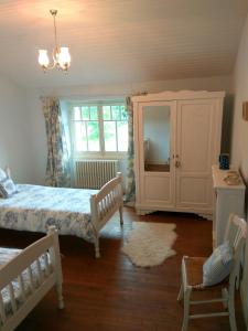 ein Schlafzimmer mit einem Bett, einem Schrank und einem Teppich in der Unterkunft Le Cerisier et Le Petit Cerisier in L'Etang des Faures 