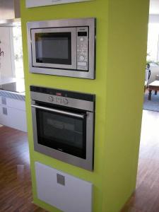 dwie mikrofale na zielonej ścianie w kuchni w obiekcie Appartement am Salamanderpark w mieście Kornwestheim