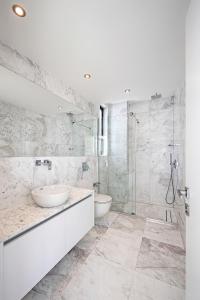 Un baño blanco con dos lavabos y una ducha. en Eros Cyprus, en Ayia Napa