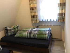 una cama con almohadas y una ventana en una habitación en Haus Nicole, en Herrischried
