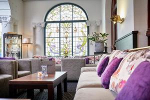 ein Wohnzimmer mit Sofas und einem Buntglasfenster in der Unterkunft Göbel`s Hotel Quellenhof in Bad Wildungen