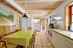 a kitchen with a green table and a dining room at Mosehuset in Koldmose