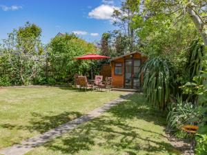 a cottage with a table and chairs and an umbrella at Garden View in Newquay
