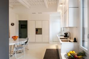 a kitchen with white cabinets and a table and chairs at Charming Flat in centro a Ferrara con posto auto in Ferrara