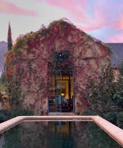 a building covered in flowers with a pool in front of it at Jonkmanshof - 20 Bath in Montagu
