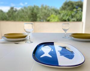 a table with a plate and two wine glasses at Apartments Pijaza in Rab