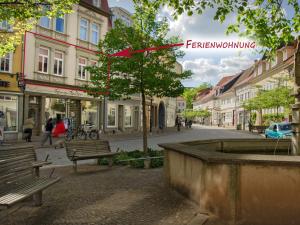 uma rua com bancos e uma árvore numa cidade em Ferienwohnung Hilbrecht em Arnstadt