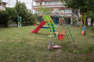 un parque infantil con tobogán y columpio en Atira Apart Hotel, en Olympiakí Aktí