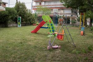 a playground with a slide and a swing set at Atira Apart Hotel in Olympiaki Akti