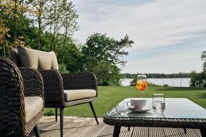 eine Terrasse mit einem Tisch und Stühlen sowie einem Glas Wein in der Unterkunft Lounge-Hotel Seeterrassen in Wandlitz