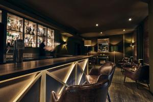 a bar with leather chairs in a room at Lounge-Hotel Seeterrassen in Wandlitz