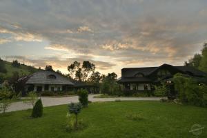 a house in a yard with a green lawn at Casa Poveste Pensiunea-Muzeu in Câmpulung Moldovenesc