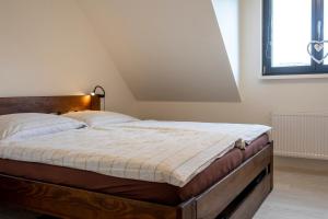 1 dormitorio con 1 cama grande y cabecero de madera en Apartman 275 - Boží Dar, en Boží Dar