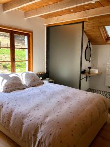 a bedroom with a large bed with a large window at Gites à la ferme à 5 minutes du lac de Gerardmer. in Sapois