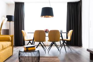 a living room with a dining room table and chairs at Gerharts Premium City Living - center of Brixen with free parking and Brixencard in Bressanone