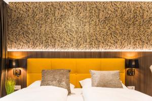 um quarto com uma cama com uma cabeceira amarela em Gerharts Premium City Living - center of Brixen with free parking and Brixencard em Bressanone