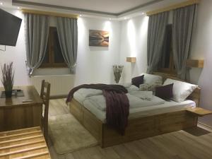 a bedroom with a bed and a desk and windows at Pansion House Prijeboj in Jezerce