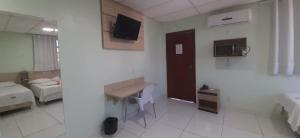 Zimmer mit einem Zimmer mit einem Bett und einem Schreibtisch in der Unterkunft Hotel Super Economico in Vitória