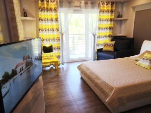 a bedroom with a bed and a large flat screen tv at Na Grobli 123 in Wrocław