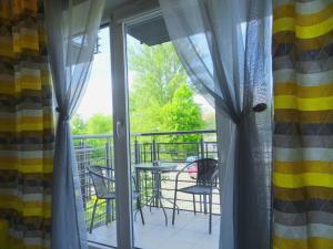 a balcony with a table and chairs through the window at Na Grobli 123 in Wrocław