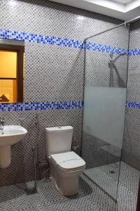 un baño con inodoro y lavabo en Asian Tower, en Al Ghurayfah