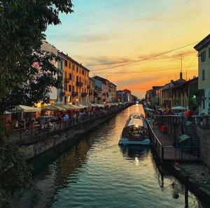 a boat on a river in a city at sunset at Hotel La Vignetta in Milan