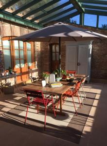 einen Holztisch und Stühle mit Sonnenschirm auf einer Terrasse in der Unterkunft Le Manoir Saint Clair in Balma