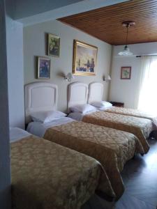 A bed or beds in a room at Kouros Hotel