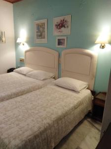 A bed or beds in a room at Kouros Hotel