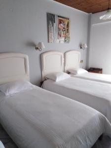 A bed or beds in a room at Kouros Hotel