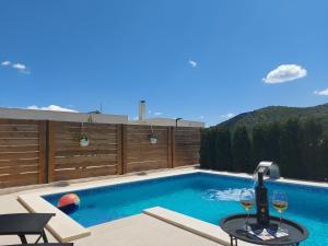 una piscina con una botella de vino y dos copas en Villa Belitzein with swimming pool en Šibenik