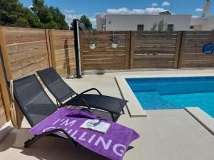 a chair and a towel next to a swimming pool at Villa Belitzein with swimming pool in Šibenik