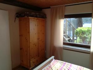 a room with a wooden cabinet next to a window at Ferienwohnung Edi Fischer in Oberfell