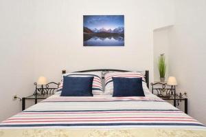 - une chambre avec un grand lit et des oreillers bleus dans l'établissement Morena, à Okrug Donji