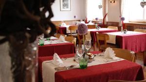 ein Restaurant mit roten und weißen Tischen und Stühlen in der Unterkunft Berghotel-Gasthof Gstrein in Vent