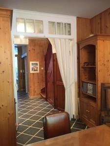 Zimmer mit einem Flur mit Holzwänden und einem Tisch in der Unterkunft appartement dans la Villa Colibri, in La Baule