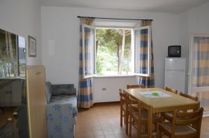 a kitchen and dining room with a table and a window at Elbamar Procchio in Procchio