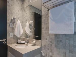a bathroom with a sink and a mirror at I am Design Hotel Campinas by Hotelaria Brasil in Campinas