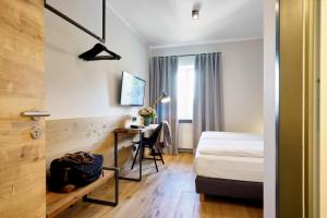 een hotelkamer met een bed en een bureau bij Gasthof Neuwirt Unterföhring in München