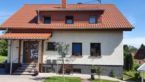 a house with an orange roof and a porch at Ferienwohnung Haus Ella in Neunkirchen