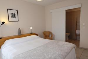 a bedroom with a white bed and a bathroom at Résidence Saint Clair in Balma